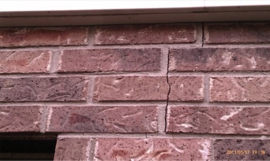 Signs of house needing leveling are evident with cracks on masonry.